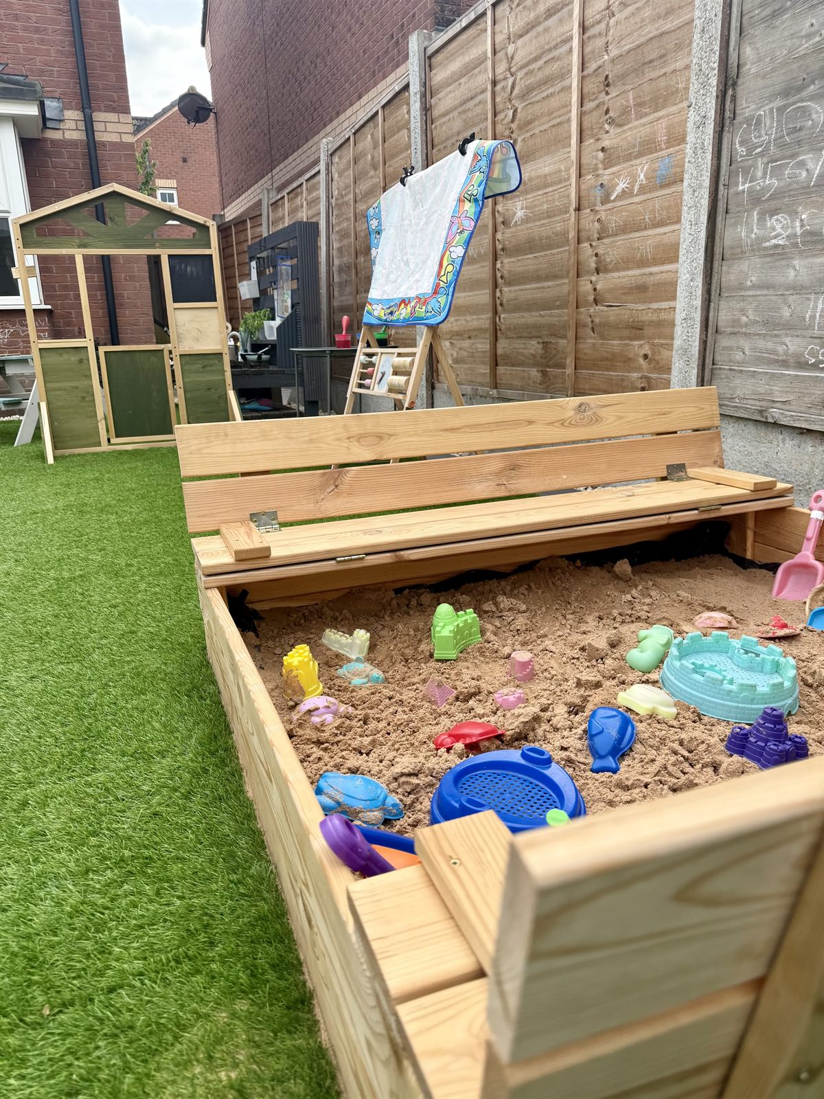 Our covered sandpit with bench lid, open for digging